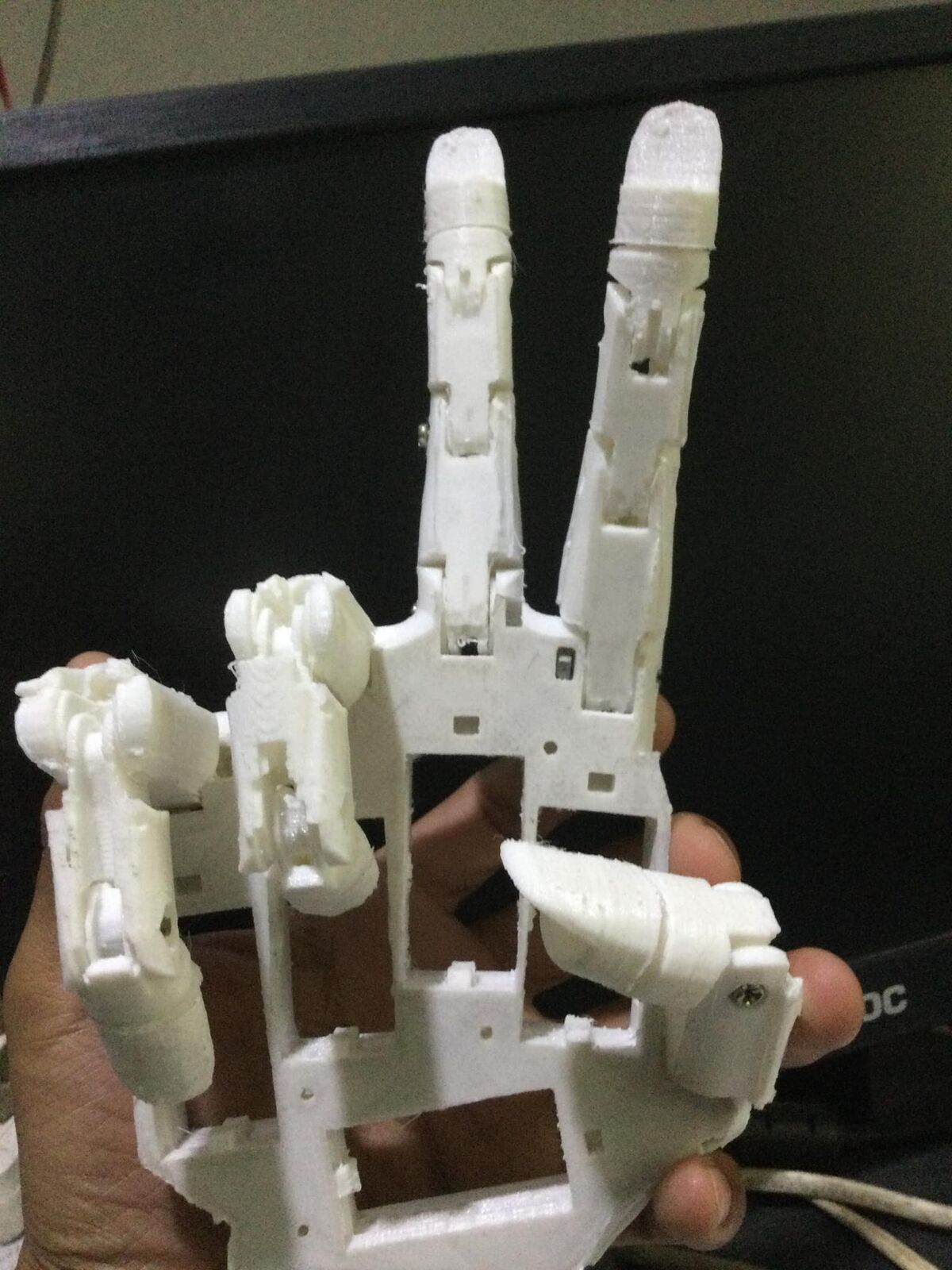 3D-printed InMoov robot hand holding up two fingers